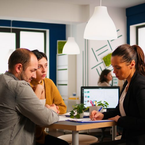 businesswoman-signing-documents-and-consultant-greeting-client-with-handshake.jpg